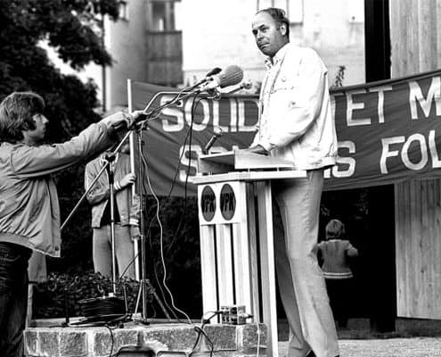 Vänsterpartiet kommunisternas ledare Lars Werner i talarstolen i Almedalen. Sverker Eriksson står framför och reglerar mikrofonen